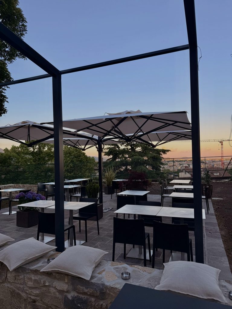 Terrazza panoramica con ombrelloni al tramonto, vista su Bergamo / Panoramic terrace with umbrellas at sunset, view over Bergamo
