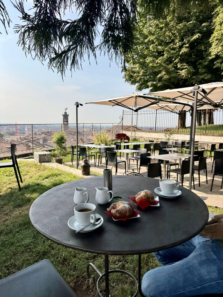 Tavolino con caffè e cornetti, affacciato sul panorama di Bergamo / Coffee and croissants on a table overlooking Bergamo